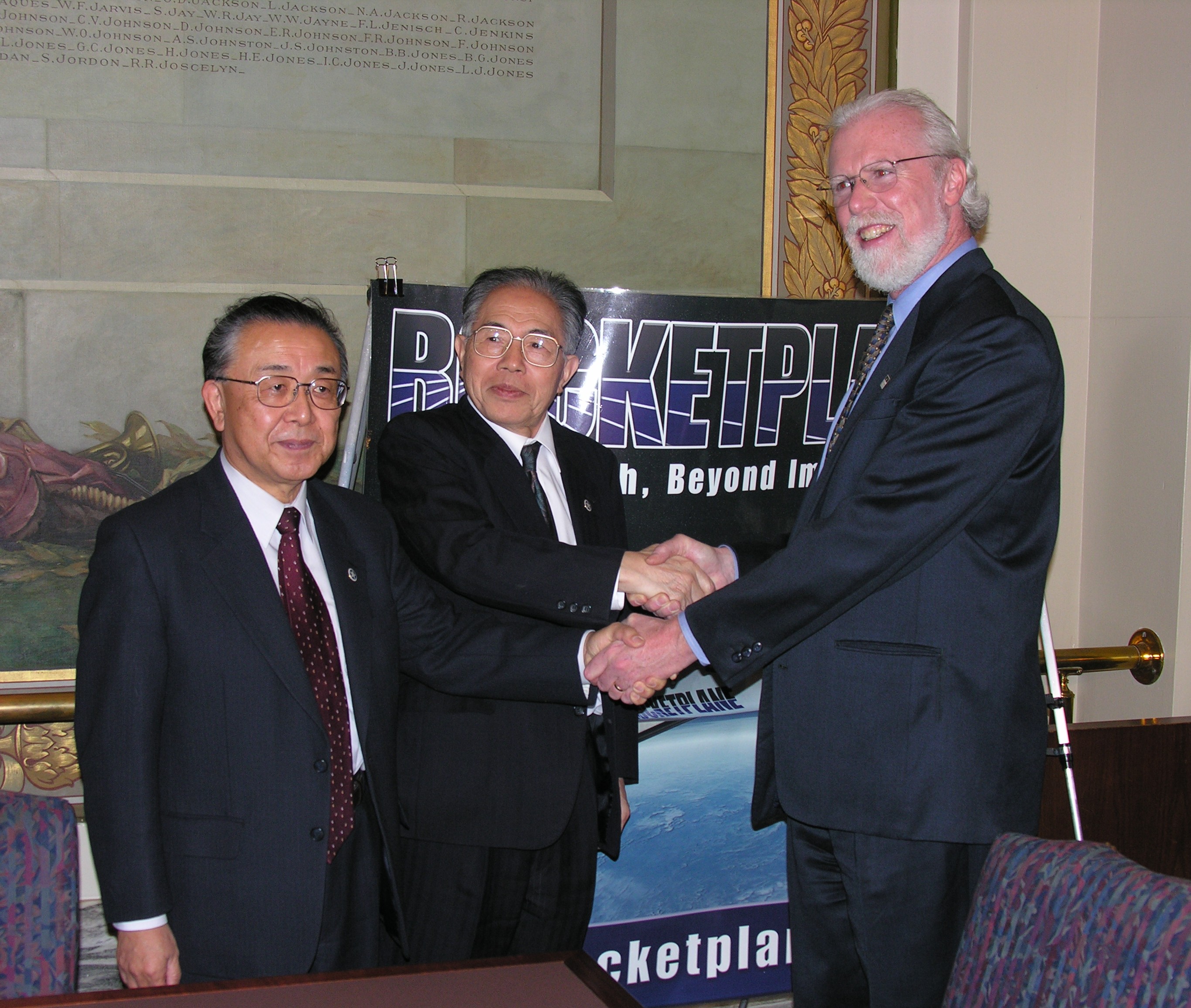 Rocketplane's Director of Business Development Charles Lauer shakes hands with Dr. Ryojira and Dr. Kenichi Ito.