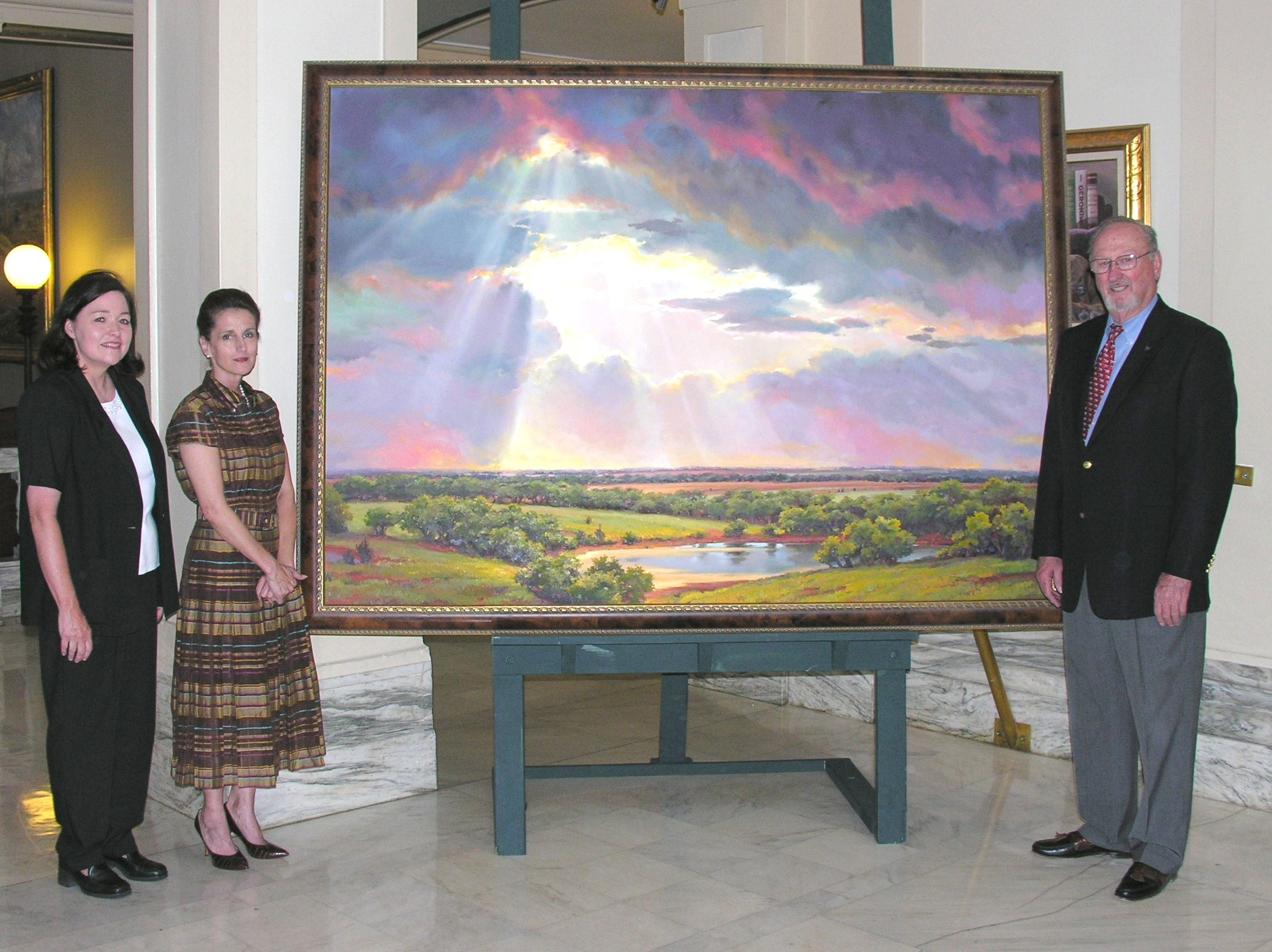Artist Linda Tuma Robertson, Barbara McCune and Charles Ford pose with the painting following the unveiling in the House Chamber.