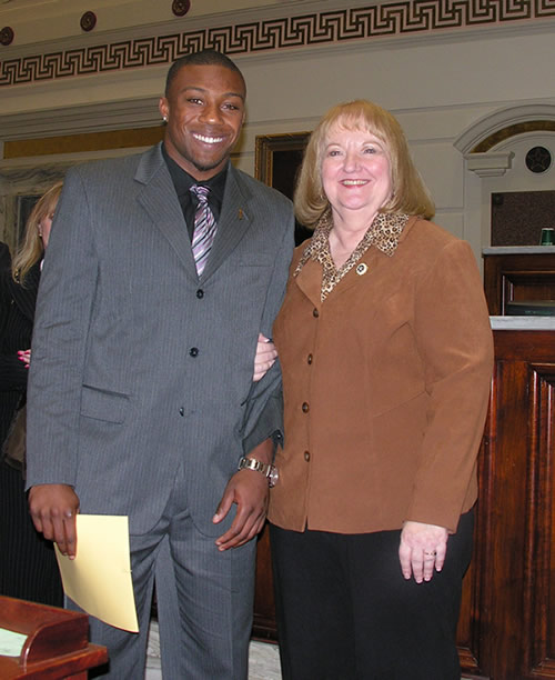 Sen. Debbe Leftwich poses with 2009 Jim Thorpe award recipient  Eric Berry.