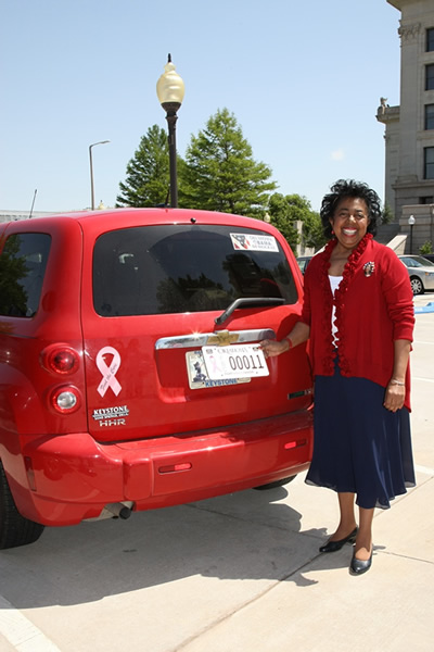 Sen. Eason McIntyre shows off her newly purchased “Fight Breast Cancer” car tag at the state Capitol.