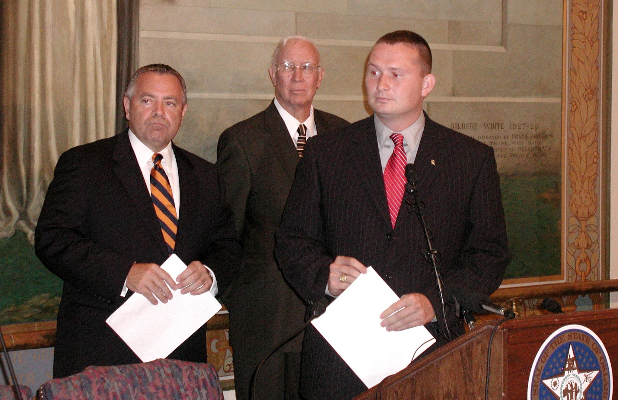 The legislators listen to questions from reporters.