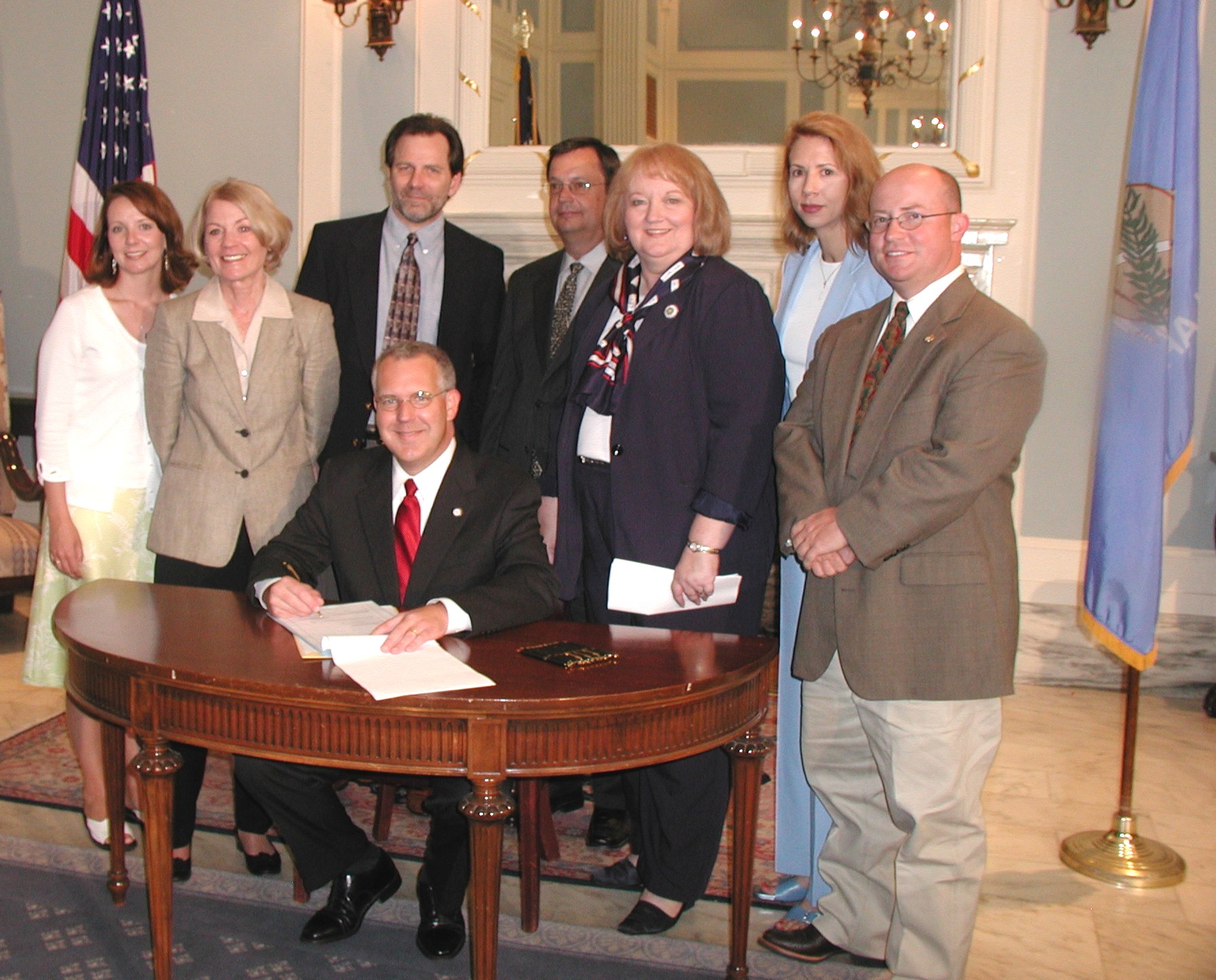 Rep. Susan Winchester and Sen.  Debbe Leftwich watch as the Governor ceremoniously sign HB 1716.