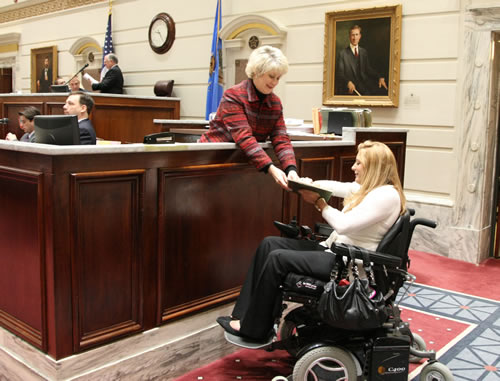 Senate Calendar Clerk Karen Fleet gives intern Hailey Mathis legislation for delivery to the House.